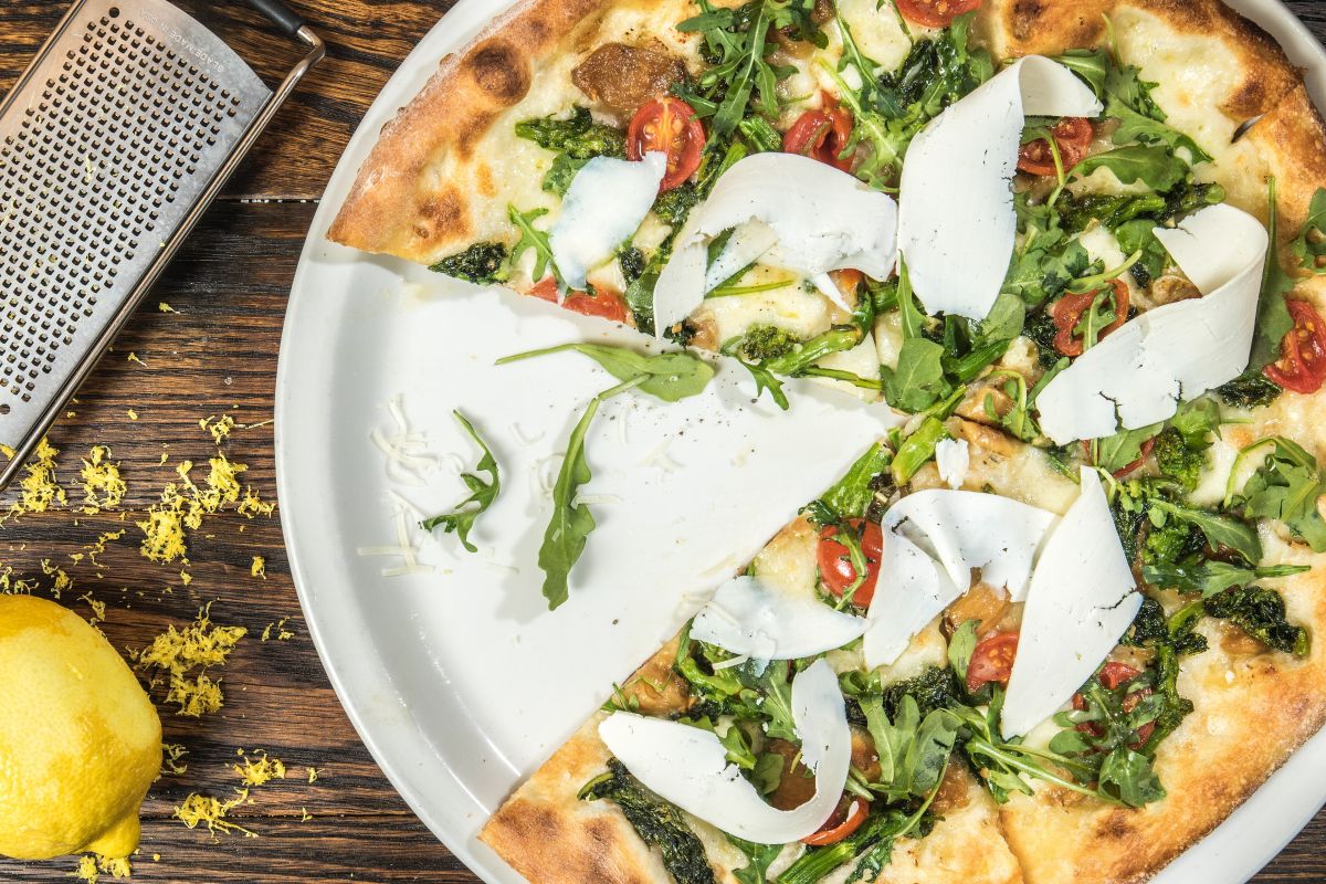 Pizza contemporanea appena uscita dal forno, vista dall'alto su fondo scuro
